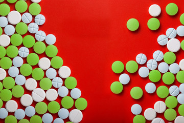 The concept of medicine. Medical green pills. On a red background. View from above .