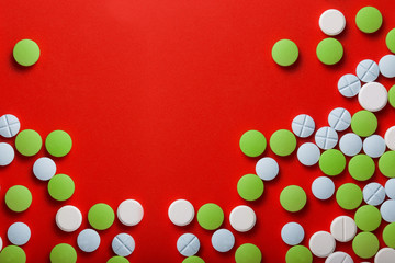 The concept of medicine. Medical green pills. On a red background. View from above .