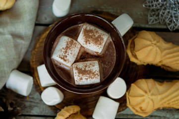 Christmas drink cocoa. Cocoa on a wooden background with marshmallows and pine cones in rustic style