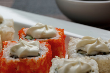 Exotically japanese seafood, roll are lying on a white plate. Close up.