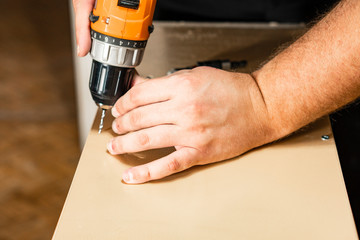 Closeup of hand holding a drill. The other hand touches the cartridge.