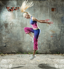 Fototapeta premium Pretty blond woman dancing in a grungy place