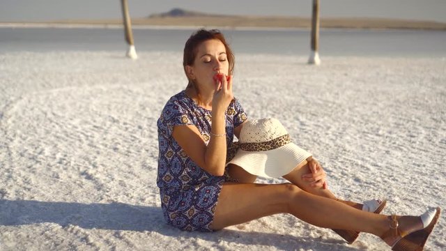 happy smiling girl enjoying the sunset, eating watermelon, sit on salt, pillars