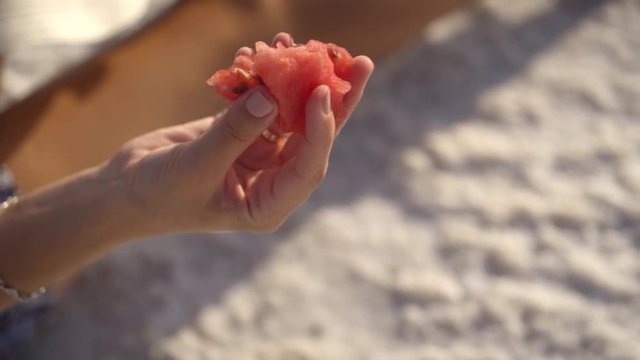 happy smiling girl enjoying the sunset, eating watermelon, sit on salt, close-up
