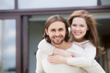 Portrait of attractive smiling married couple outdoors, looking at camera. Close up head shot young...