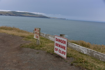Danger Signs on a Cliff Looking Out Over the Ocean