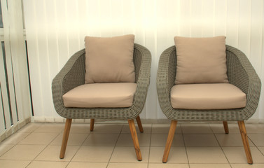 fauteuils en rotin gris dans la véranda