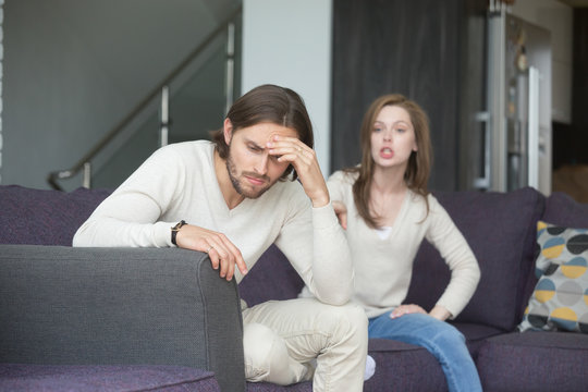 Married couple quarreling at home. Wife emotionally screaming, shouting at husband, drama queen nagging, angry man looking away. Misunderstanding break up, problems and trouble in relationship concept