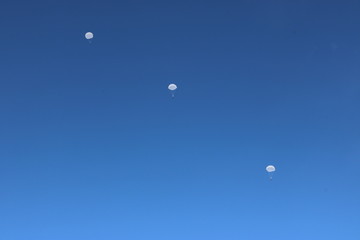 blue sky and parachutists