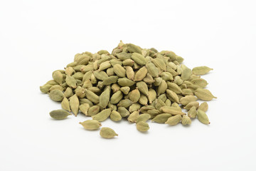 Cardamomo en grano sobre fondo blanco