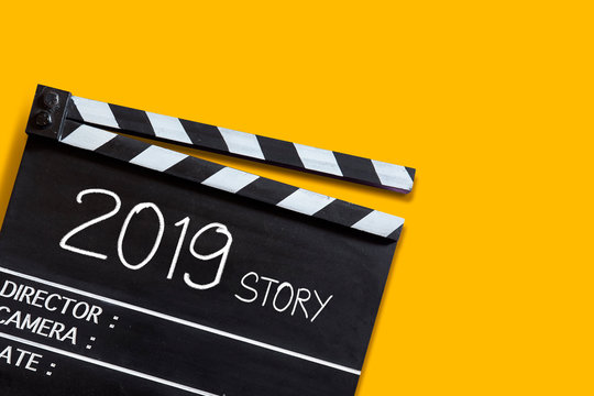 2019 story ,text title on movie Clapper board on orange colour backgrounds