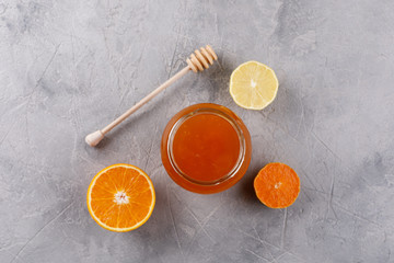 Honey in a glass jar. Set against colds with citrus orange and lemon.