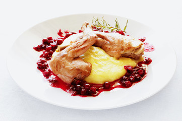 brased rabbit with potato and sauce of cranberies and white wine decorated with fried rosemary