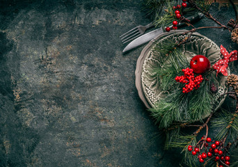 Christmas background with festive table place setting decoration on dark rustic background, top view with copy space for your design: invitation, greetings, menus, recipes and so on