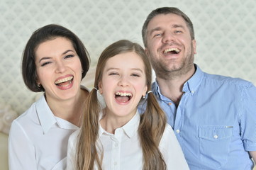 Portrait of a beautiful parents and daughter posing in room