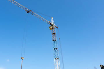 blue summer sky against which the tower crane