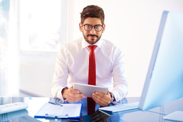 Naklejka premium Businessman using digital tablet while working in the office