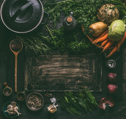 Dark rustic food background frame with vegetarian ingredients: root vegetables, spices, cast iron...