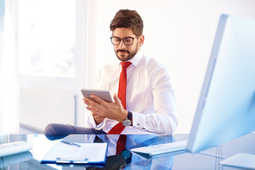 Handsome businessman working on digital tablet in the office