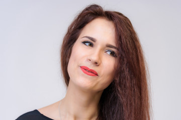 Fototapeta premium Studio portrait concept of a smiling beautiful brunette girl talking on a white background.