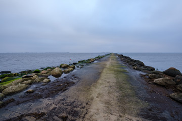Fototapeta na wymiar breakwater in sea with old metal railing port dock