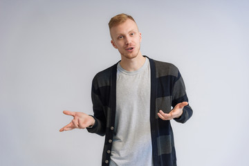 Studio portrait concept of a smiling young man talking on a white background.