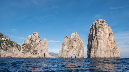 Fototapeta na wymiar Sea stacks off the coast of Capri, Italy. They are named Stella, Faraglione di Mezzo with the arch, and Fraglione di Furori.