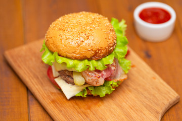 Fresh tasty burger on wood table