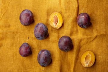 Ripe plums on linen background