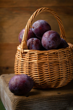 Ripe blue plums in wicker basket