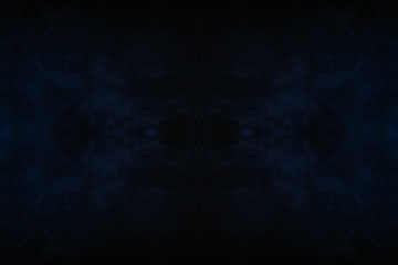 Abstract thick colored smoke on a black background with a monster face. The concept of light laser show at a musical concert and a print on a T-shirt