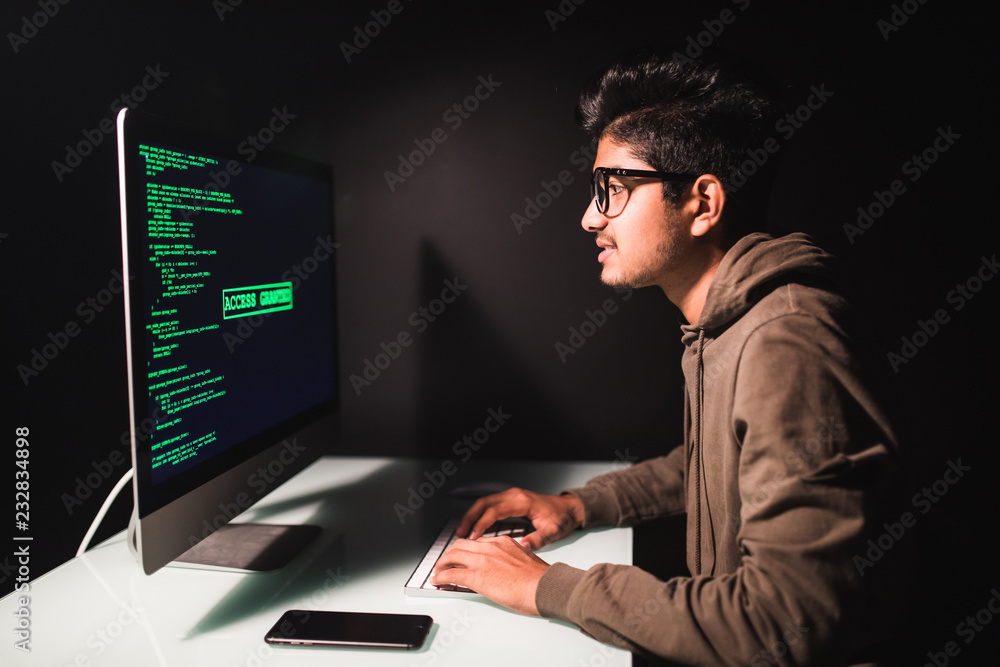 Wall mural indian man programmer working on desktop computer at white desk in office.