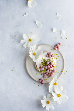 Flowers strewn on bagel with cream cheese and pink currant berries