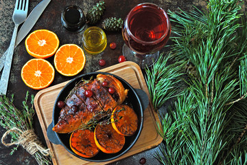 Christmas dinner. Chicken breast baked with tangerines and cranberries. Christmas tree branches and...