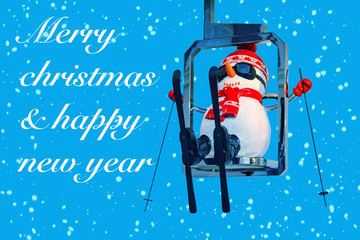 Obraz premium Merry Christmas. Christmas Greeting Card Template with Festive Snowman with a Red Hat. Snowman in alpine skiing is riding a ski lift.