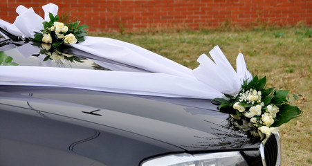 Closeup view on flower decoration on modern wedding car.