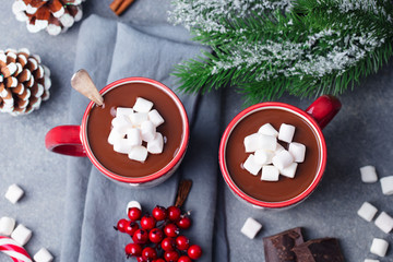 Hot chocolate with marshmallows in Christmas mugs on grey background. Top view.