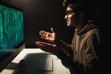 Indian Hacker attack the server in the dark gesturing with hands