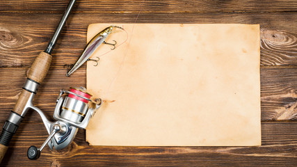 Fishing gear - fishing, fishing, hooks and baits, an old sheet of paper on a wooden background....