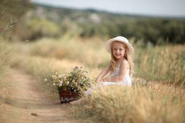 Fototapeta na wymiar Girl in a field with flowers in their hands