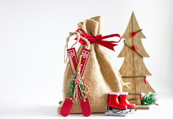 Christmas background - a bag of canvas with gifts, a number of decorative Christmas toys: skates, skis, sleds, nuts, cones