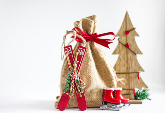 Christmas background - a bag of canvas with gifts, a number of decorative Christmas toys: skates, skis, sleds, nuts, cones