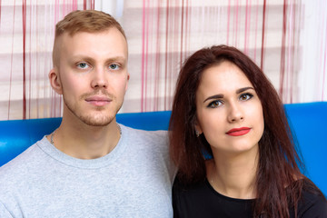 The concept of family conflict, problems, relationships of young disgruntled husband and wife in a room on the sofa.