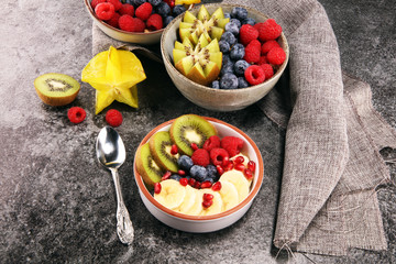 fruit bowl. Bowl of healthy fresh fruit salad on rustic background