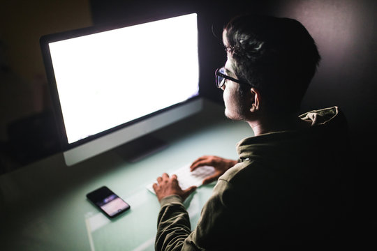Indian hacker using computer white screen trying to commit computer crime. Hacker and computer threat crime concept