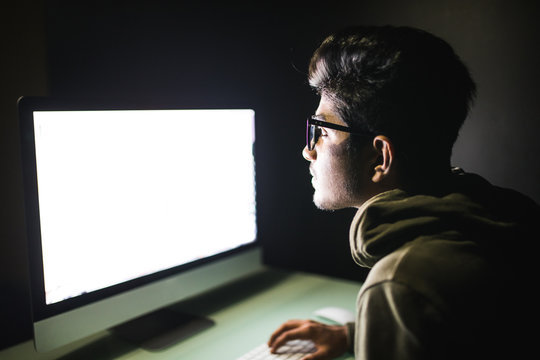 Indian hacker using computer white screen trying to commit computer crime. Hacker and computer threat crime concept