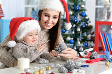 Fototapeta na wymiar Portrait of smiling mother and daughter preparing for Christmas