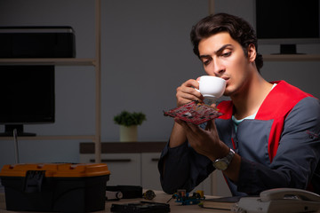 Young handsome repairman repairing computer 