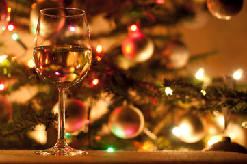 Glass of white wine and christmas tree