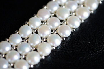 White pearl necklace on a dark background close up